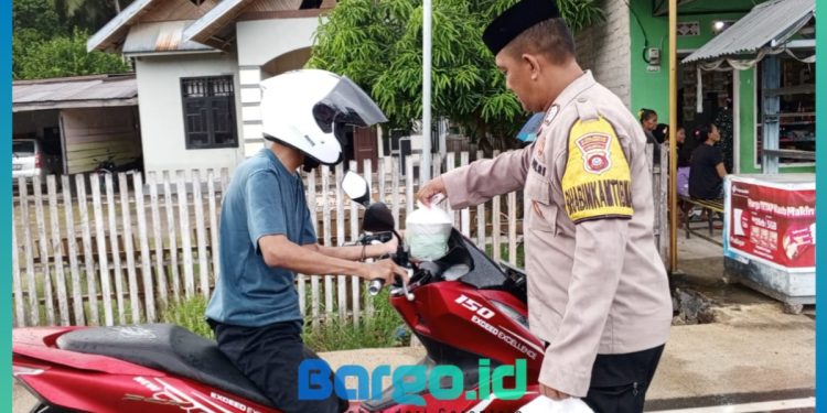 Bhabinkamtibmas Polsek Patilanggio dan Aparat Desa Manawa Berbagi Takjil untuk Warga di Bulan Ramadhan